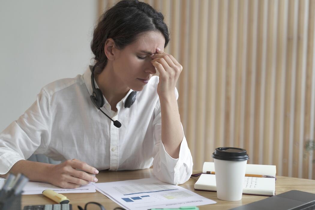 ADHD treatment for adults - Tired spanish female home office worker massaging nose or inner corners of her eyes