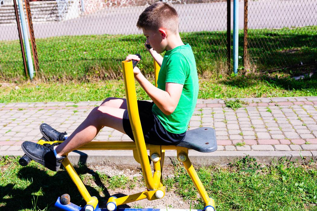 adhd treatment for children - Boy exercising on outdoor fitness equipment. Healthy lifestyle and outdoor workout.