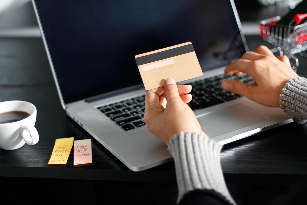 How much is sildenafil oral jelly? - Shopping online concept. Woman holding gold credit card in hand and online shopping using on laptop at home.