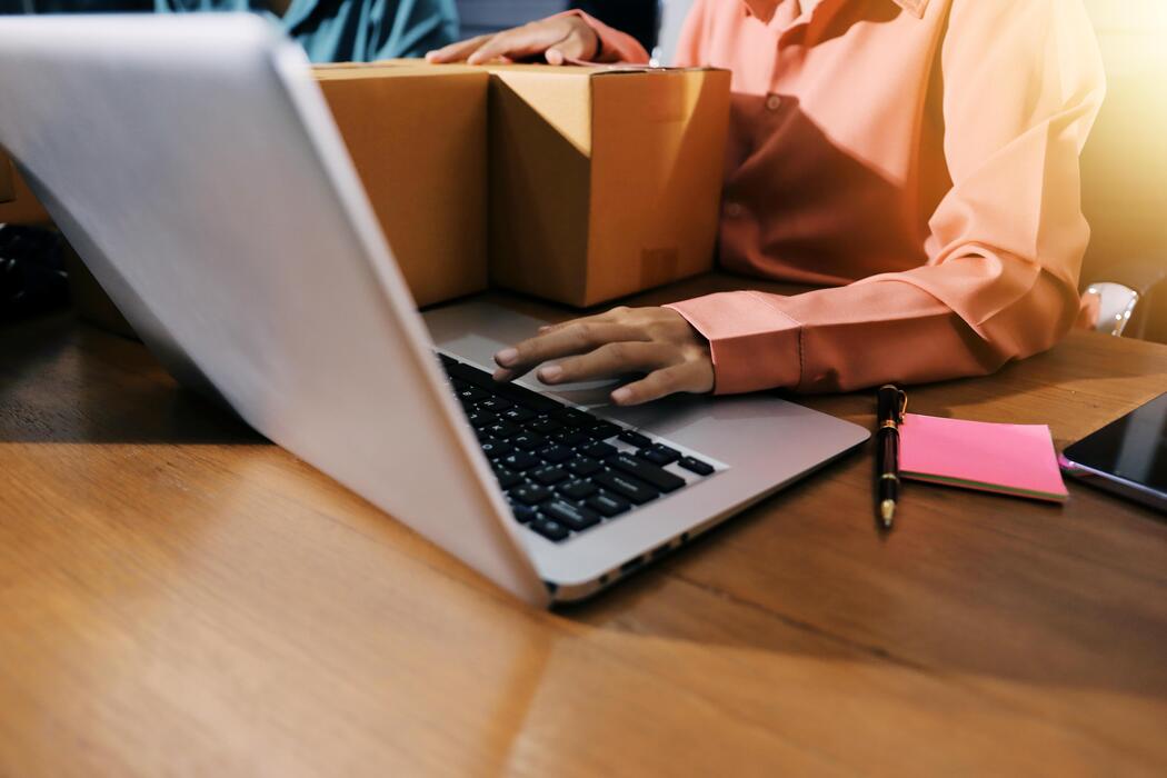 Can I buy Viagra over the counter? - A woman working on her laptop while holding a box