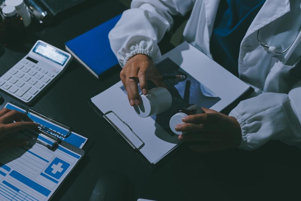 Is PharMerica real? - A doctor is working on a computer and a patient is sitting at a desk