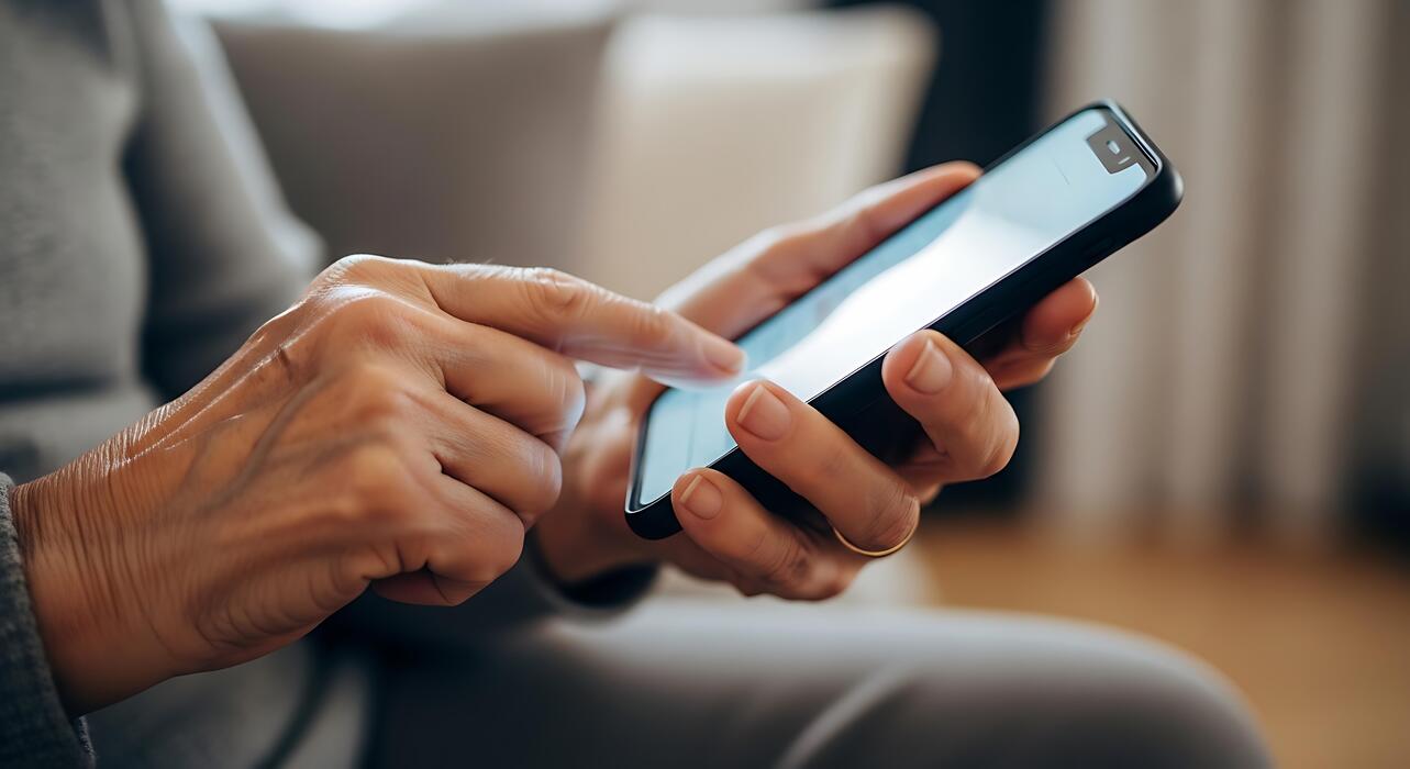Pharmacy Planet UK - Senior hands mindfully navigating a smartphone for daily well-being and connection