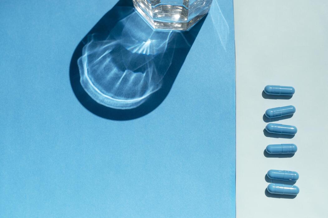 What is the new sleeping tablet in the UK? - Medical pills for treatment and a glass of water on a blue studio background