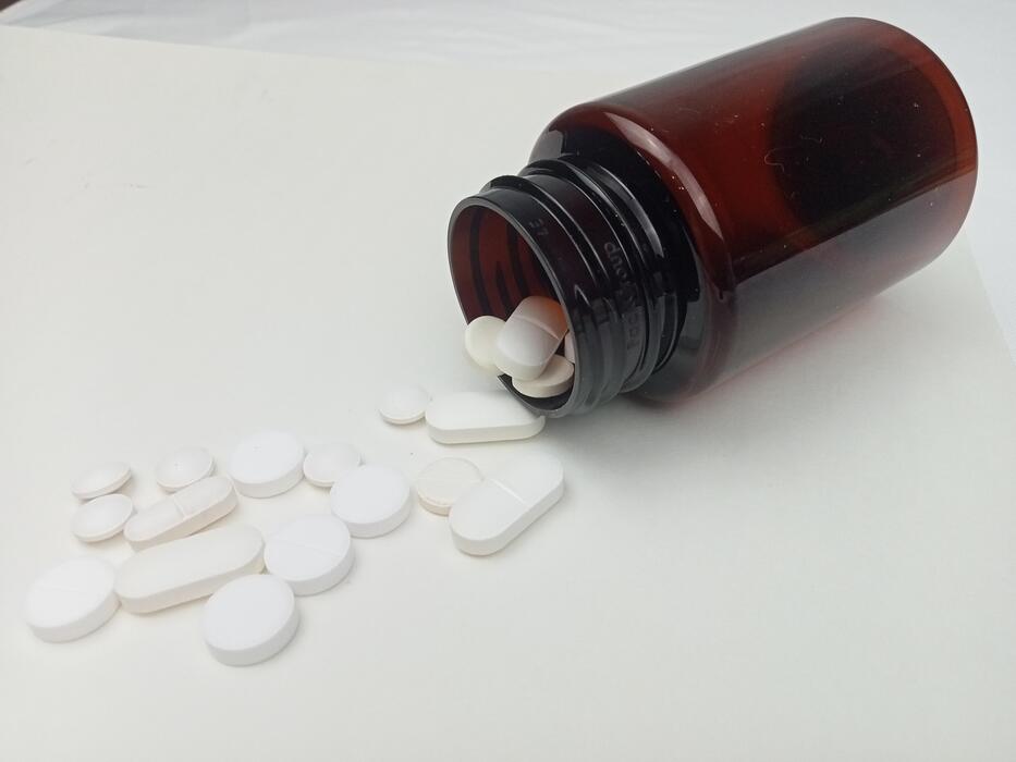 What is the strongest sleeping pill in the UK? - White pills spilling from brown medicine bottle on white background