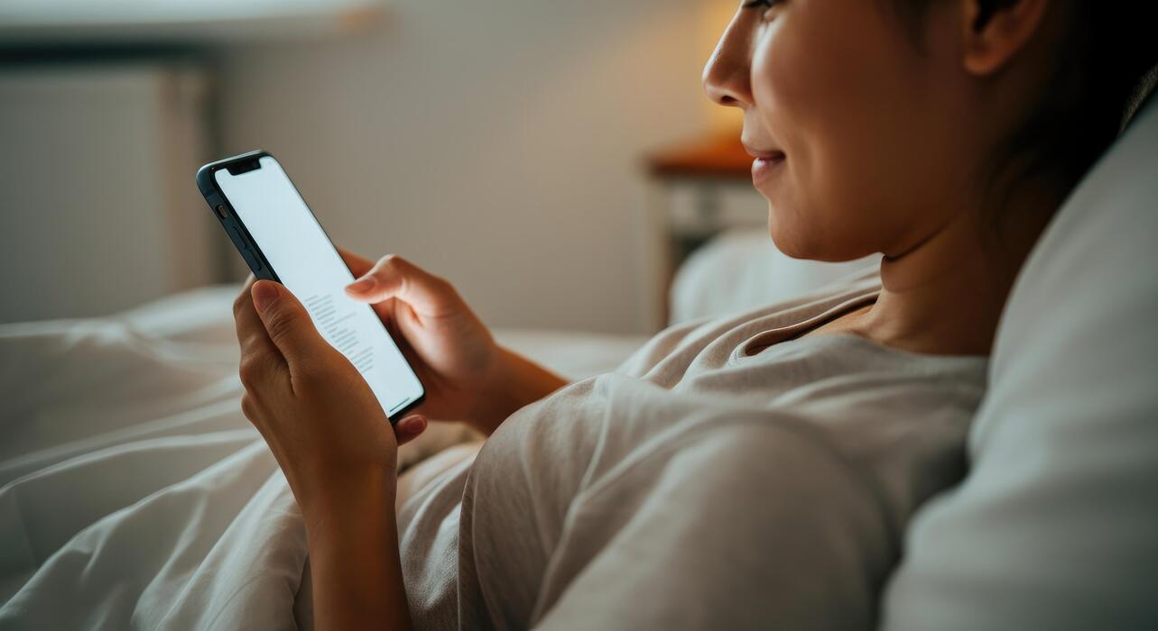 how to fall asleep faster with adhd - Asian woman using smartphone in bed, relaxed evening reading