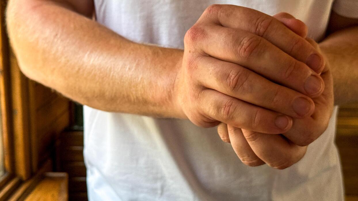 Home remedies to fall asleep quickly - A Caucasian mans hands, clasped resolutely, symbolize unity and contemplation during the tranquil Scandinavian Midsummer festival