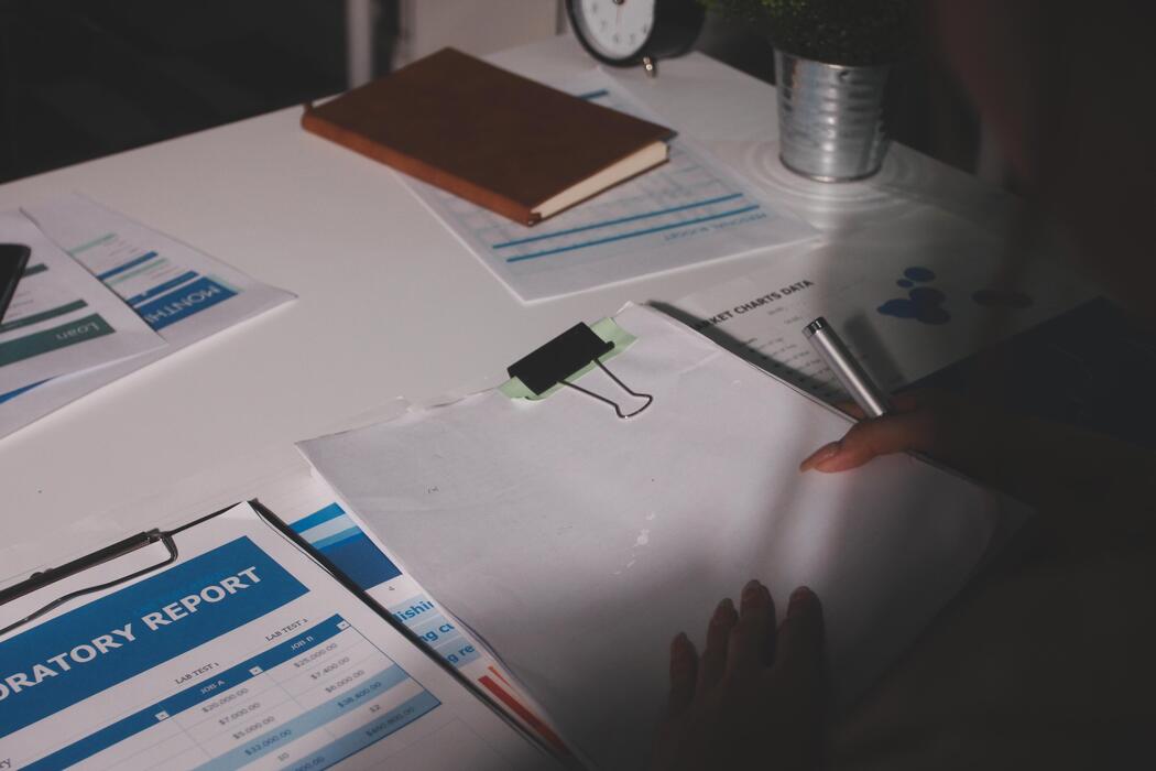 small business website design agency - A woman's hand holding a pen and paper at a desk