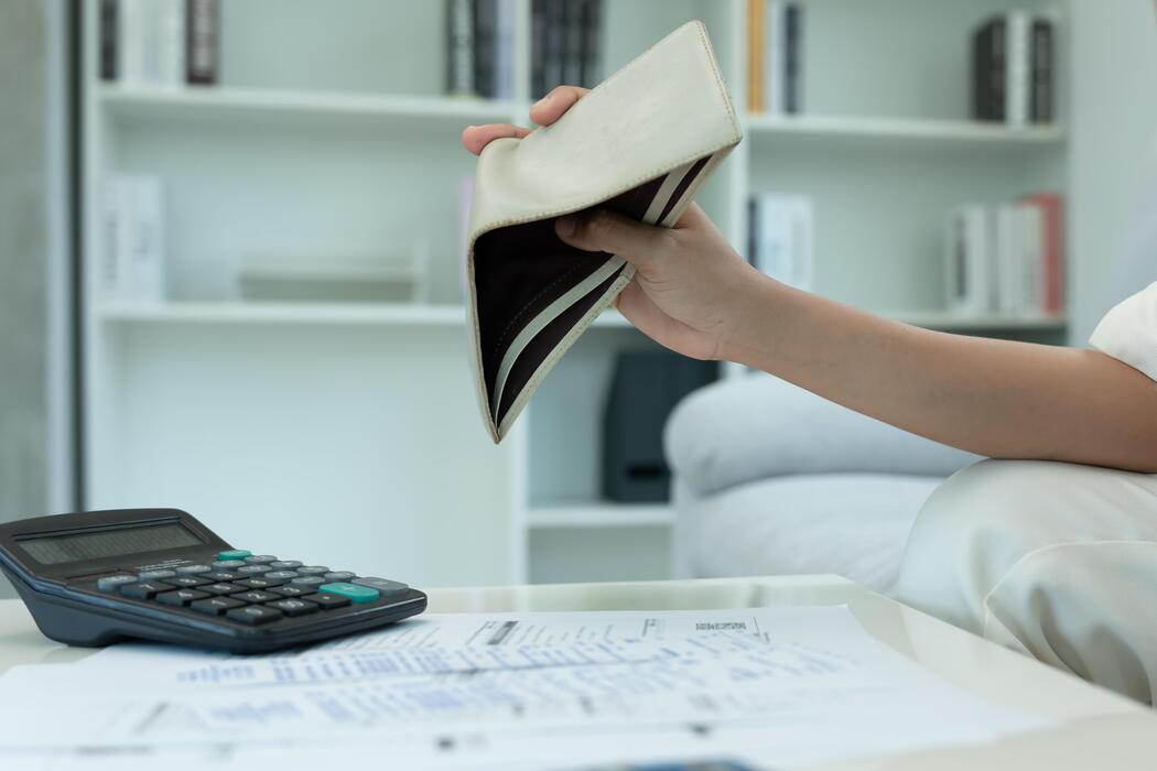 Cheapest website builder UK - headache woman with large bills or invoices, No money on pocket to pay to expenses and credit card debt. shortage, Financial problem, bankruptcy, mortgage, loan, bankrupt, poor, empty wallet