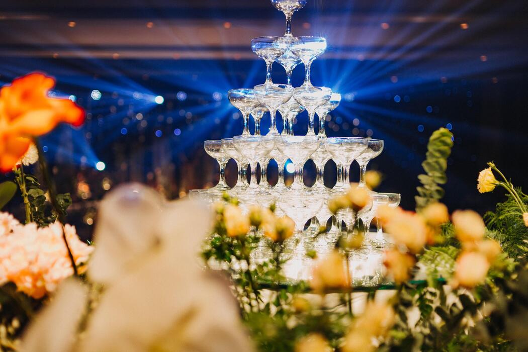 Wedding cart rental - Flower arrangement for summer wedding, made of roses and green branches on a dinner table in the restaurant. , glass and plates in the restaurant outside on a windy day with film grain effect