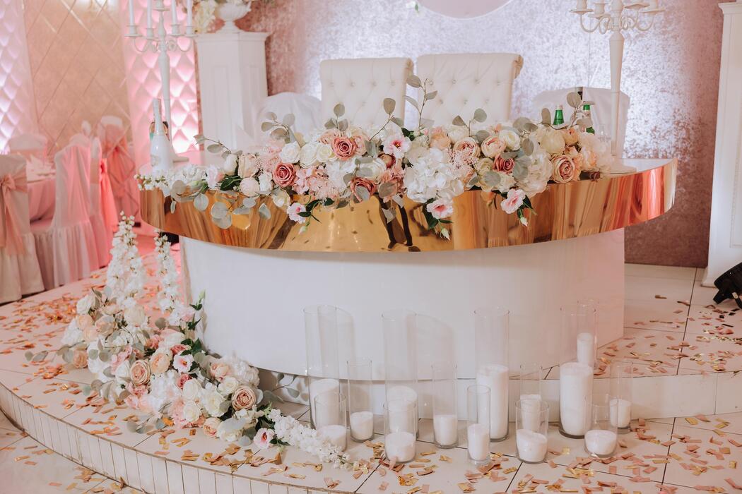 Wedding cart rental - Romantic table setting in a restaurant for a holiday. Wedding decor for the newlyweds at the banquet. Floristry of fresh flowers and candles, boho style. Catering for the bride and guests.
