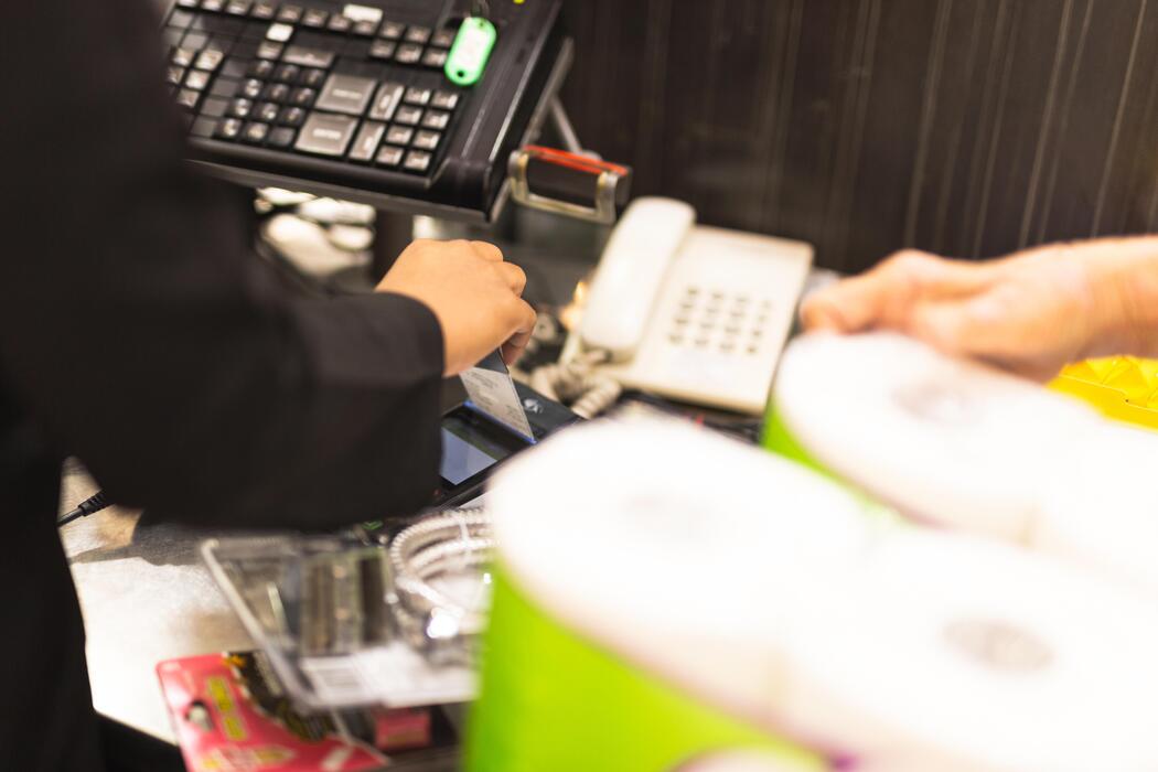 Superkings cigarettes price - Customer inserting a credit card into payment terminal at supermarket checkout.