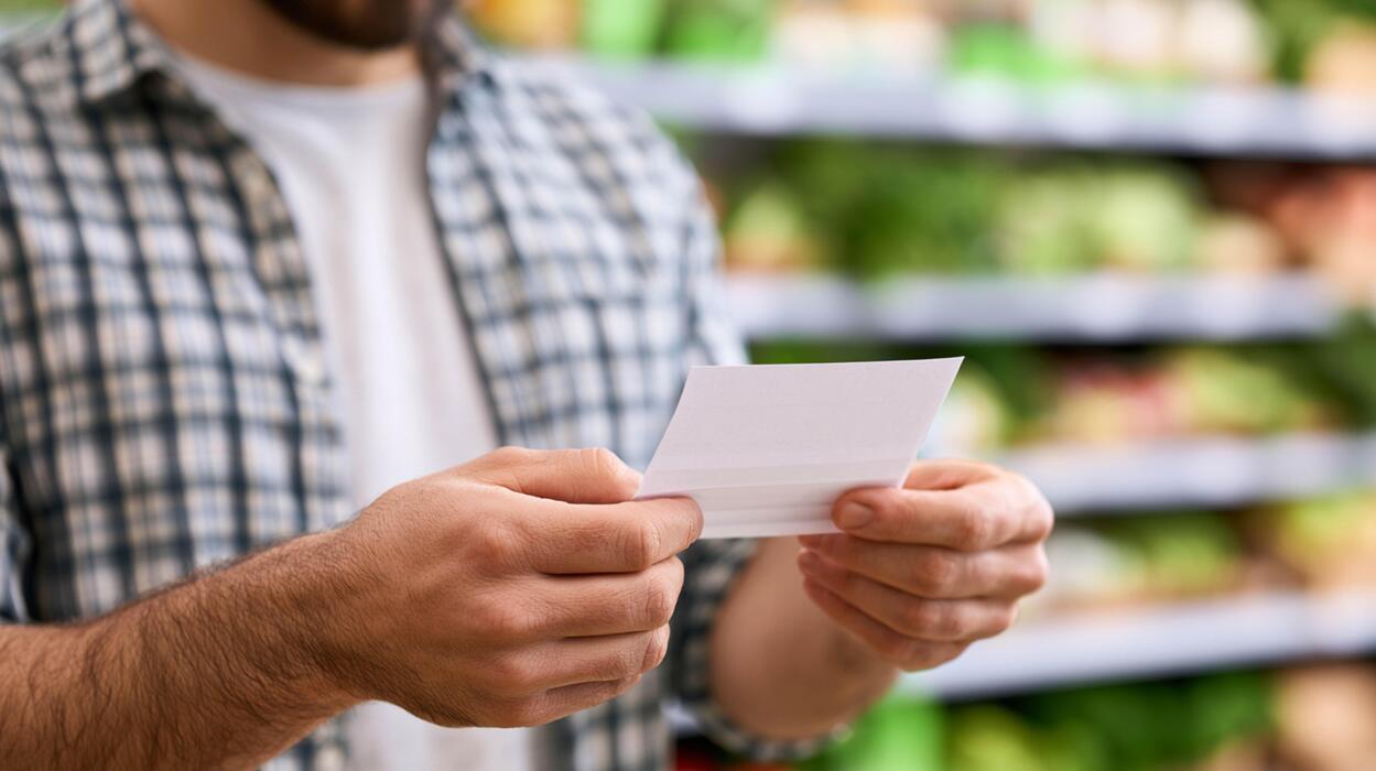 superkings cigarettes uk - Close-up of Man Reading Grocery Shopping List in Supermarket