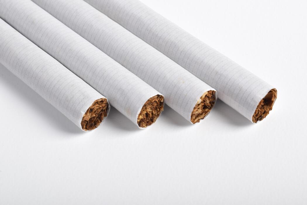 superkings cigarettes uk - Four white filter cigarettes lined up diagonally on a clean white background, close-up.